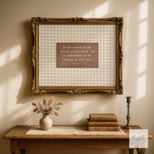 May include: A framed print with a gold ornate frame. The print features a beige gingham pattern and a central rectangular panel with text that reads, "Do not conform to the pattern of this world, but be transformed by the renewing of your mind."