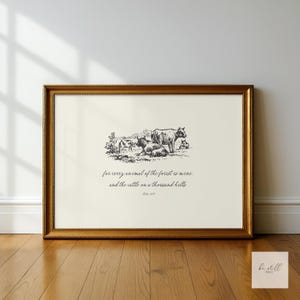 Może przedstawiać: Oprawiony wydruk ze złotą ramą. Grafika przedstawia czarno-białą ilustrację krów na polu, z tekstem poniżej: "for every animal of the forest is mine. and the cattle on a thousand hills."