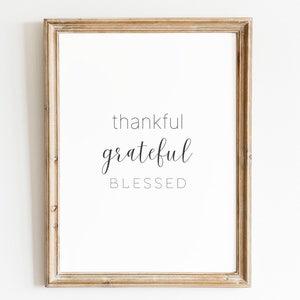 May include: A framed print with the words "thankful grateful blessed" in a simple, modern font.
