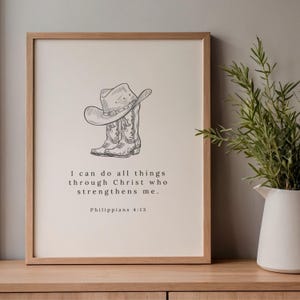 May include: A framed print featuring a line drawing of a cowboy hat and boots. The artwork includes the text "I can do all things through Christ who strengthens me. Philippians 4:13."