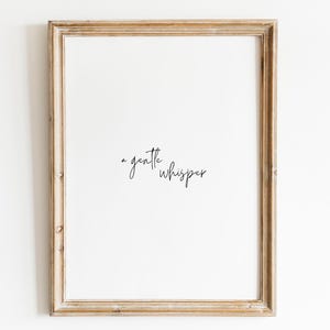 Peut inclure: Une impression encadrée avec le texte "a gentle whisper" en écriture cursive noire sur fond blanc.