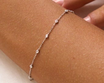 May include: A delicate silver chain bracelet with small, clear gemstones.
