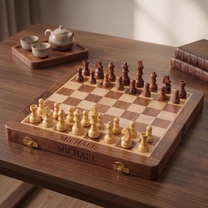 May include: A wooden chess set featuring a folding board with the name MICHAEL engraved on the front edge. The set includes light and dark wooden chess pieces arranged on the board, which has alternating light and dark square patterns.