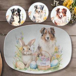 May include: A white oval serving platter with a watercolor illustration of a brown bunny rabbit and a brown and white Australian Shepherd dog. The dog is standing next to a basket of colorful Easter eggs. The text "Liesl" is printed on the basket.