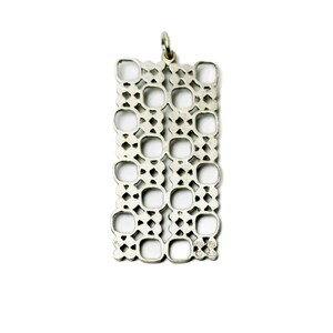 Puede incluir: Colgante rectangular plateado con dise&ntilde;o calado. El colgante presenta un patr&oacute;n repetitivo de cuadrados y rombos, con un peque&ntilde;o lazo en la parte superior para una cadena. El colgante se muestra sobre un fondo blanco.