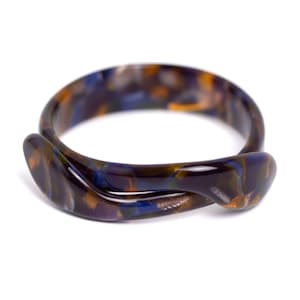 May include: A twisted bangle bracelet with a marbled pattern in shades of brown, blue, and purple.
