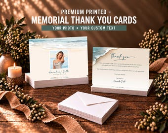 May include: Memorial thank you cards featuring a beach scene with a photo of a person, the name Amanda W. Sills, and dates. The cards include the text Thank you and a message of gratitude. A stack of white envelopes is placed in the foreground.