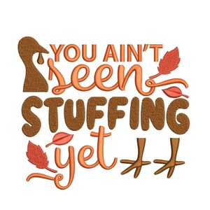 Könnte beinhalten: Ein Stickmuster zum Thema Thanksgiving mit einem Truthahn und dem Text "You ain't seen stuffing yet" sowie Herbstblättern.