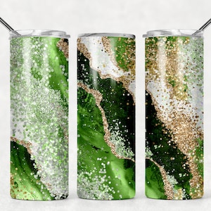 May include: Three stainless steel tumblers with green, white, and gold glitter abstract designs. The tumblers have a lid and a straw.