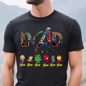 May include: Black t-shirt featuring the word "DAD" in a colorful, comic-style font with the Avengers logo. Below the text are cartoon illustrations of several Avengers characters, each with a "NAME" label. The shirt is a casual wear item.