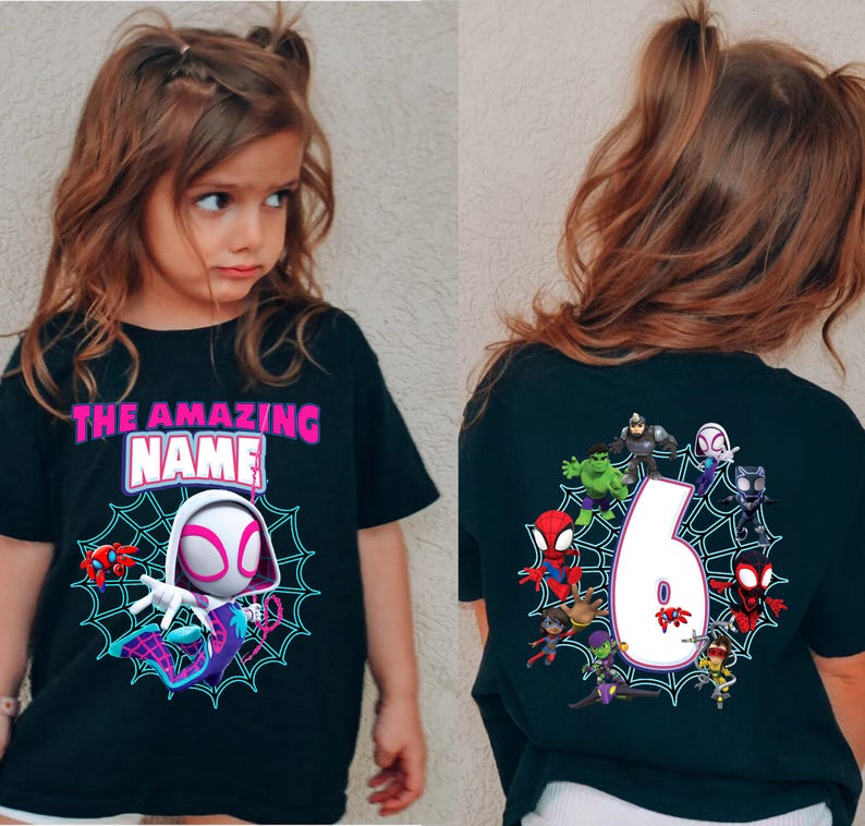 Op de afbeelding: Zwart T-shirt met een Spider-Gwen afbeelding en de tekst "THE AMAZING NAME" in roze en wit. De achterkant van het shirt toont het nummer 6 omringd door Spider-Man personages. Een leuk en kleurrijk ontwerp voor kinderen.