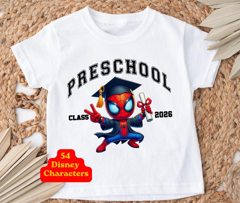 Puede incluir: Una camiseta blanca de manga corta con un gr&aacute;fico de un personaje de Spider-Man con birrete y toga de graduaci&oacute;n, sosteniendo un diploma. El texto dice PRESCHOOL CLASS 2026. Una insignia roja muestra 54 Disney Characters.