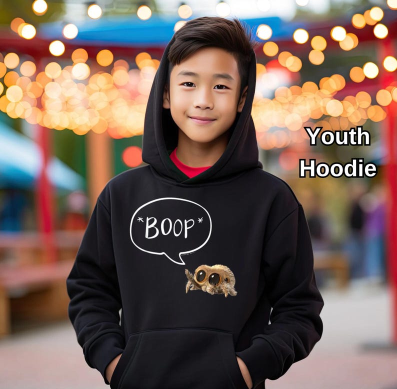 Puede incluir: Sudadera con capucha negra para j&oacute;venes, con bolsillo de canguro y capucha. La sudadera presenta un bocadillo blanco con la palabra "BOOP" y un dibujo de ara&ntilde;a. Tambi&eacute;n se ve el texto "Youth Hoodie".