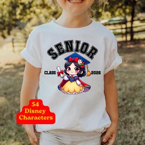 Puede incluir: Una camiseta blanca con el gr&aacute;fico de un personaje de dibujos animados con cabello negro, un lazo rojo y una falda amarilla, que lleva un birrete azul y sostiene un diploma. El texto dice SENIOR CLASS 2026. Una insignia roja dice 54 Disney Characters.