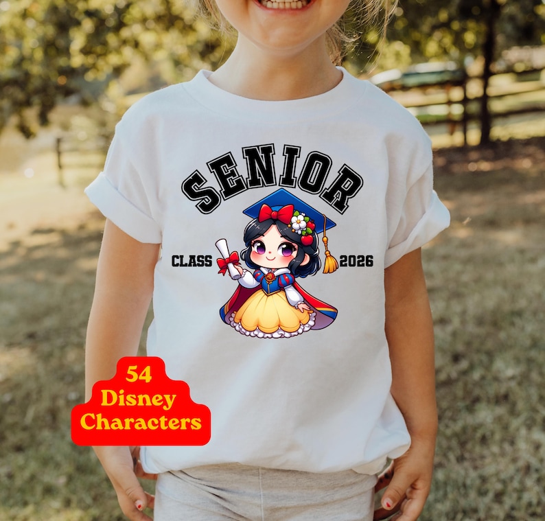 Puede incluir: Una camiseta blanca con el gr&aacute;fico de un personaje de dibujos animados con cabello negro, un lazo rojo y una falda amarilla, que lleva un birrete azul y sostiene un diploma. El texto dice SENIOR CLASS 2026. Una insignia roja dice 54 Disney Characters.