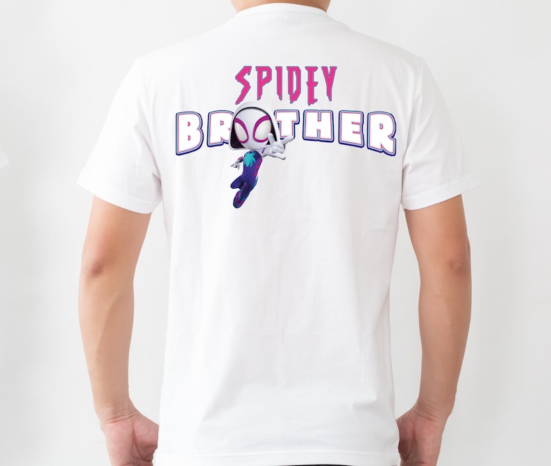 Op de afbeelding: Wit T-shirt met de tekst "SPIDEY BROTHER" in paars en blauw. Het ontwerp bevat een cartoon illustratie van een Spider-Woman personage. Het shirt is gemaakt van een zacht, comfortabel materiaal.