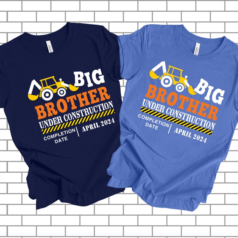 May include: Two t-shirts, one navy blue and one light blue, with a construction theme. Each shirt features a yellow and white excavator graphic and the text "BIG BROTHER UNDER CONSTRUCTION" with the completion date "APRIL 2024".