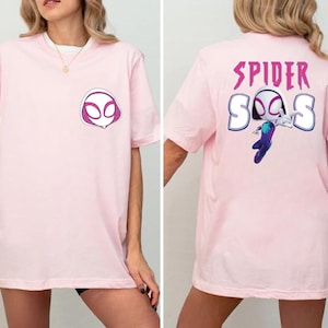 Op de afbeelding: Lichtroze t-shirt met een Spider-Gwen ontwerp. De voorkant toont een masker graphic, terwijl de achterkant de woorden "SPIDER" en "SOS" met een karakter illustratie toont. Een casual, comfortabel t-shirt.