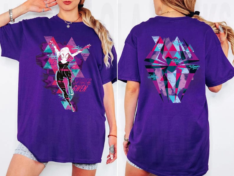 May include: A purple t-shirt featuring a graphic of a superheroine in a dynamic pose, with the name "GWEN" below. The design incorporates geometric shapes and vibrant colors. The back of the shirt has a similar geometric design.