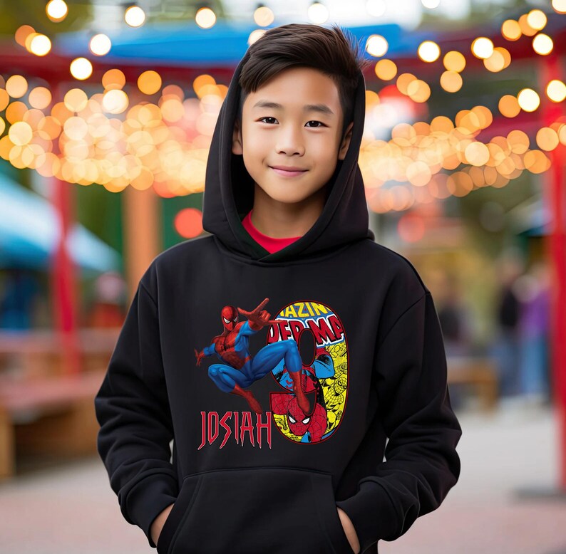 Puede incluir: Sudadera con capucha negra con un gr&aacute;fico de Spiderman en un traje rojo y azul, el texto "Amazing Spiderman" y el nombre "Josiah" impreso en la parte delantera.