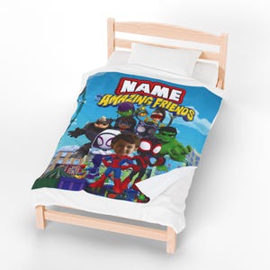 May include: A personalized blue blanket featuring a group of cartoon superheroes with the text "NAME His Amazing Friends". The blanket is on a wooden bed frame with a white pillow.