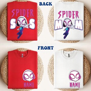 Op de afbeelding: Rode en witte t-shirts met een Spider-Gwen-ontwerp. De achterkant van het rode shirt zegt "SPIDER SOS" met een Spider-Gwen-afbeelding. De achterkant van het witte shirt zegt "SPIDER MOM". De voorkant van de shirts heeft een Spider-Gwen-masker en het woord "NAME".