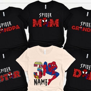 Puede incluir: Conjunto de seis camisetas negras con dise&ntilde;os de Spider-Man en rojo y blanco. Las camisetas presentan el texto "Spider Grandma", "Spider Grandpa", "Spider Mom", "Spider Dad", "Spider Sister" y "Spider [Name]" con un n&uacute;mero 3.