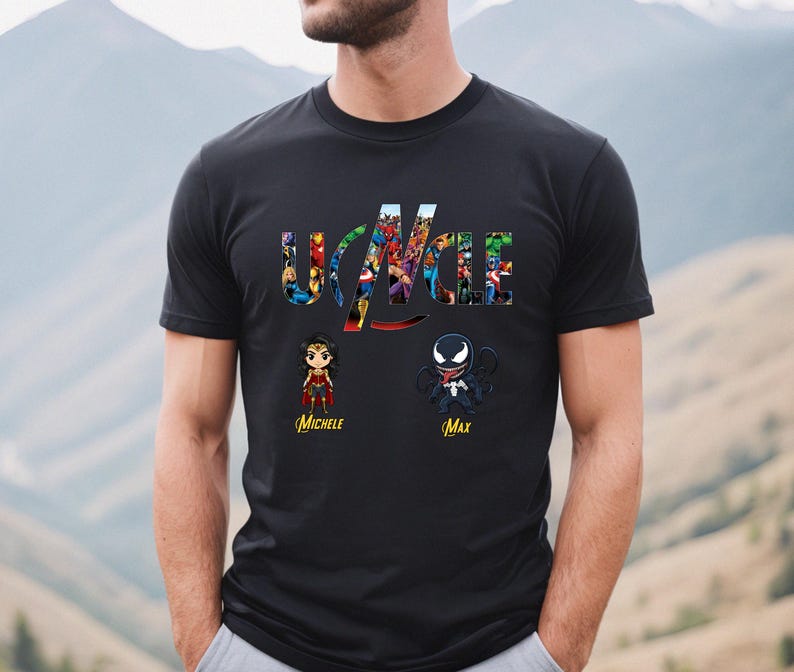 Peut inclure: Un t-shirt noir &agrave; manches courtes avec le mot UNCLE en grandes lettres remplies d'images de super-h&eacute;ros. Sous le texte se trouvent deux illustrations de personnages de style chibi &eacute;tiquet&eacute;es Michele et Max en &eacute;criture cursive jaune.