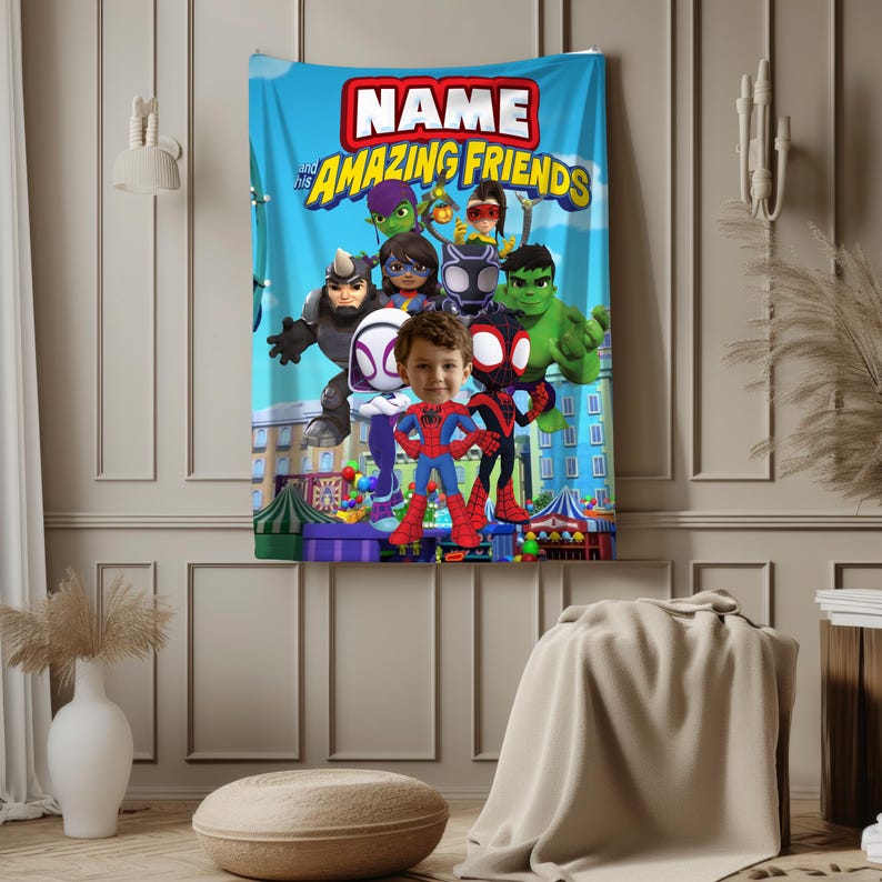 May include: A blue blanket featuring the text "NAME and his AMAZING FRIENDS" in red and yellow. The blanket has cartoon illustrations of superheroes and a child's face in the center. The background shows a cityscape.
