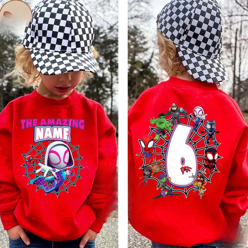 Op de afbeelding: Een rode trui met een Spider-Gwen-ontwerp en de tekst "THE AMAZING NAME". De achterkant van de trui toont het cijfer 6, omringd door verschillende superhelden. Het kind draagt een zwart-wit geblokte baseballcap.