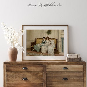 May include: A vintage painting of three women sitting on a yellow couch in a room with a fireplace. The women are wearing long dresses and are looking at a book. The painting is framed in a brown frame.