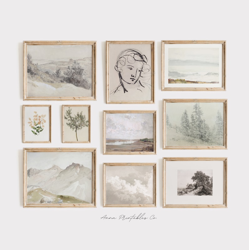 May include: A gallery wall featuring nine framed prints with various nature scenes, including landscapes, flowers, and trees. The frames are all made of light wood and have a simple, elegant design. The prints are all in muted tones of green, brown, and white, giving the gallery wall a calming and serene feel. The text "Anna Printables Co." is visible at the bottom of the image.