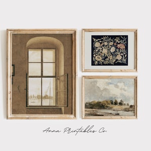 May include: Three framed prints in a gallery wall arrangement. The left print is a sepia-toned image of a window with a view of a harbor. The center print is a dark blue and white floral tapestry. The right print is a landscape painting of a river with trees and a cloudy sky.
