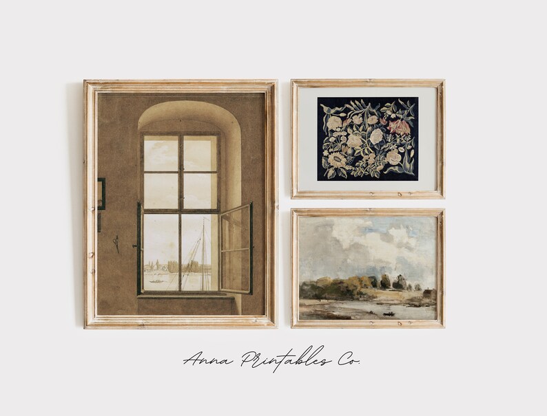 May include: Three framed prints in a gallery wall arrangement. The left print is a sepia-toned image of a window with a view of a harbor. The center print is a dark blue and white floral tapestry. The right print is a landscape painting of a river with trees and a cloudy sky.