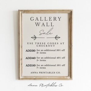 May include: A printable sign with a brown wood frame and a white background. The sign says "Gallery Wall Sale" and lists discount codes for purchases of 3 or more items. The codes are ADD30, ADD40, and ADD50. The sign also says "Anna Printables Co."