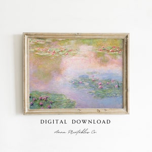 Op de afbeelding: Een ingelijste digitale print van een waterlelievijver, met roze en groene waterleliebladeren en bloemen. Het kunstwerk heeft een zachte, impressionistische stijl met een gedempt kleurenpalet. De lijst is van licht, verweerd hout. Tekst onderaan luidt "DIGITALE DOWNLOAD" en "Anna Printables Co."