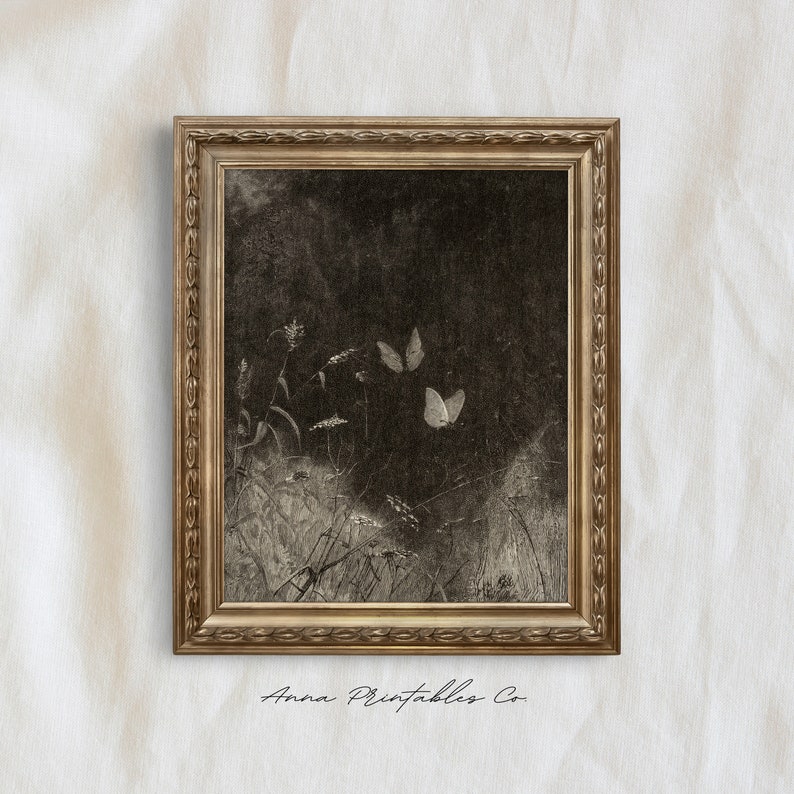 May include: A framed sepia-toned print featuring a field scene with butterflies. The artwork has a dark background with light-colored butterflies and plants. The frame is gold-colored with ornate detailing. The text "Anna Printables Co" is at the bottom.