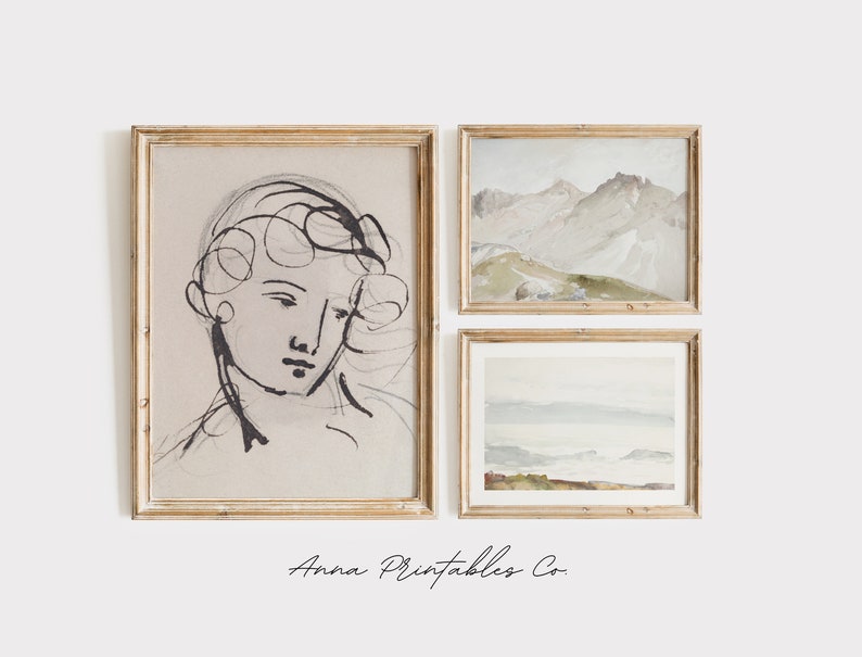 May include: Three framed art prints on a white wall. The left print is a black and white line drawing of a person's face. The middle print is a watercolor painting of a mountain range. The right print is a watercolor painting of a seascape.