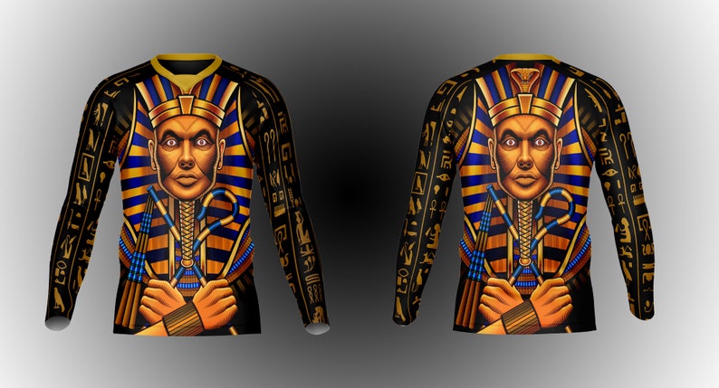May include: Black long-sleeve shirt with a gold and blue pharaoh design. The pharaoh is wearing a gold crown and holding a staff. The shirt is covered in hieroglyphics.