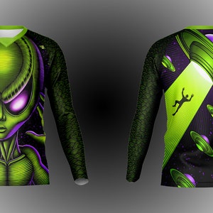 May include: A long-sleeved shirt with a green alien face on the front and a green UFO with a beam of light on the back. The shirt has a black background with purple and green accents.
