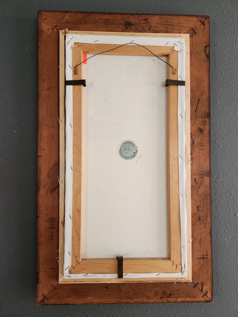May include: Back of a framed painting with a wooden frame. The canvas is stretched and stapled to a wooden frame. The back of the canvas has a metal wire for hanging. The frame is a dark brown color.