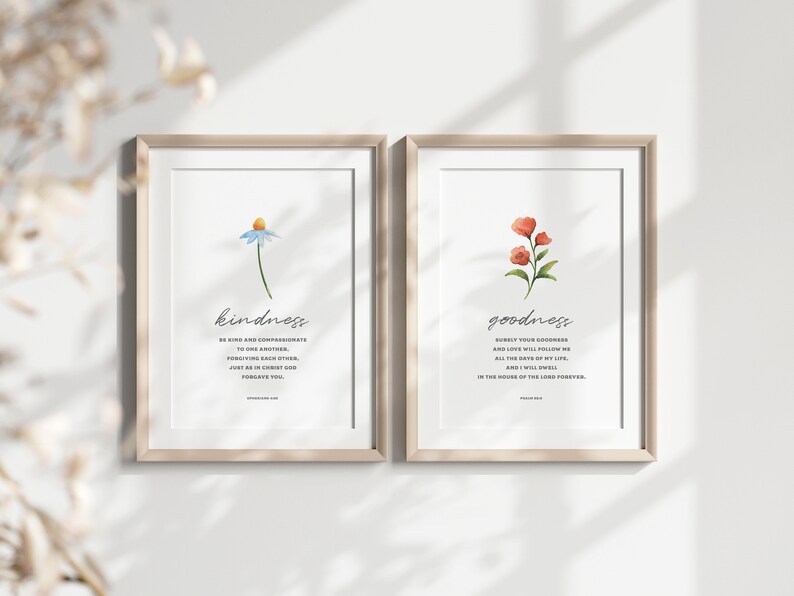 K&ouml;nnte beinhalten: Zwei gerahmte Drucke mit Aquarell-Blumenillustrationen und inspirierenden Zitaten. Der linke Druck zeigt eine blaue Blume mit dem Wort "kindness" und ein Zitat &uuml;ber Freundlichkeit und Mitgef&uuml;hl. Der rechte Druck zeigt eine rote Blume mit dem Wort "goodness" und ein Zitat &uuml;ber G&uuml;te und Liebe.