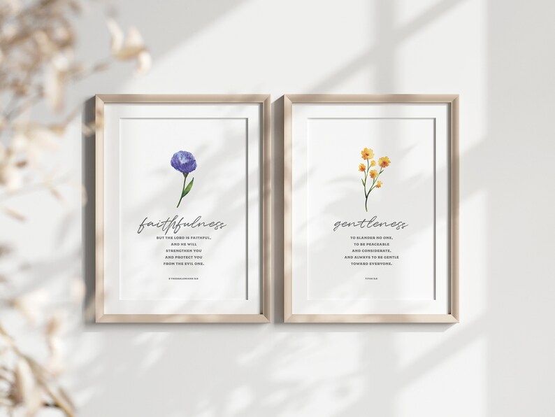K&ouml;nnte beinhalten: Zwei gerahmte Drucke mit Aquarell-Blumenillustrationen und inspirierenden Zitaten. Der linke Druck zeigt eine lila Blume mit dem Wort "Treue" und einem Zitat aus Psalm 33,4. Der rechte Druck zeigt gelbe Blumen mit dem Wort "Sanftmut" und einem Zitat aus Kolosser 3,12.