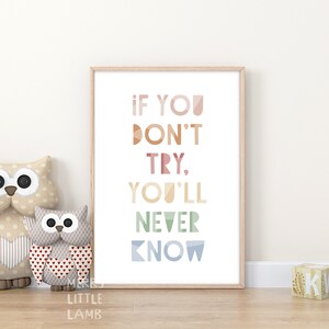 May include: A framed print with the text "If you don't try, you'll never know" in a colorful geometric font. The print is displayed on a wooden floor with two owl stuffed toys in front of it.