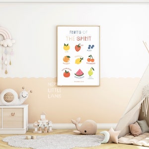 May include: A colorful printable poster with the text "Fruits of the Spirit" and illustrations of fruit representing different virtues, such as joy, peace, patience, kindness, goodness, faithfulness, gentleness, self-control. The poster is framed and hanging on a wall in a nursery with a teepee tent and other children's toys.