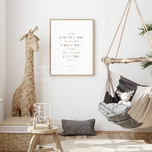 May include: A framed print with a white background and colorful text that reads "Before I formed you in the womb I knew you. Before you were born I set you apart. Jeremiah 1:5".