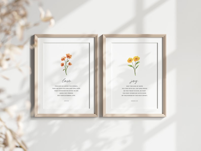 K&ouml;nnte beinhalten: Zwei gerahmte Drucke mit Aquarell-Blumenillustrationen und Bibelversen &uuml;ber Liebe und Freude. Der Druck auf der linken Seite zeigt einen Strau&szlig; orangefarbener Blumen mit dem Vers "Denn so sehr hat Gott die Welt geliebt, dass er seinen einzigen Sohn hingab, damit jeder, der an ihn glaubt, nicht verloren geht, sondern ewiges Leben hat." Der Druck auf der rechten Seite zeigt einen Strau&szlig; gelber Blumen mit dem Vers "Der Gott der Hoffnung erf&uuml;lle euch mit aller Freude und Frieden im Glauben, damit ihr durch die Kraft des Heiligen Geistes &uuml;berstr&ouml;mt werdet von Hoffnung."