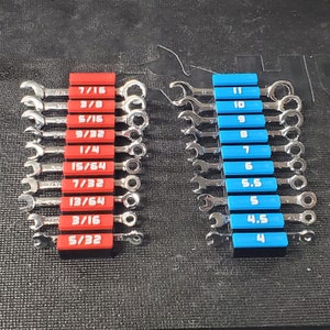 May include: A set of 12 wrenches with red and blue handles. The wrenches are arranged in two rows, with the red handles on the left and the blue handles on the right. The wrenches are labeled with their sizes in fractions of an inch.