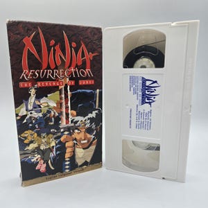 May include: A VHS tape and case for "Ninja Resurrection: The Revenge of Jubei." The case is brown with a red and gold title and anime artwork. The white VHS tape has a label with the title and a blue logo.