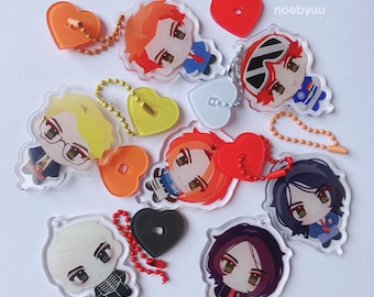 May include: A collection of acrylic charms featuring chibi-style characters with diverse hair colors and outfits. Each charm includes a colorful heart-shaped plastic attachment and a matching ball chain. The text noebyuu is visible in the top right.